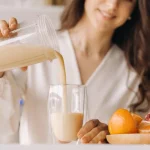 Sieviete gatavo olbaltumvielu kokteili olbaltumvielu diētai