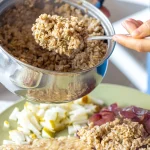 Karstajā putrā no katliņa ievietotas vārītas graudaugi — piemērs, kā termolabilās uzturvielas samazinās termiskās apstrādes laikā.